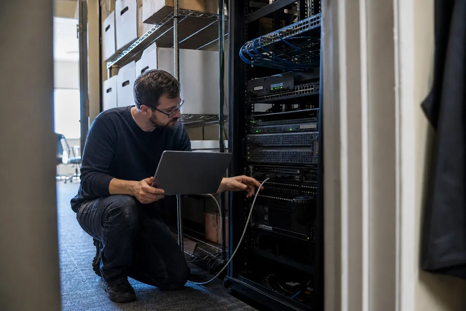 IT consultant at a law firm server closet checking an on-premises document server before a migration